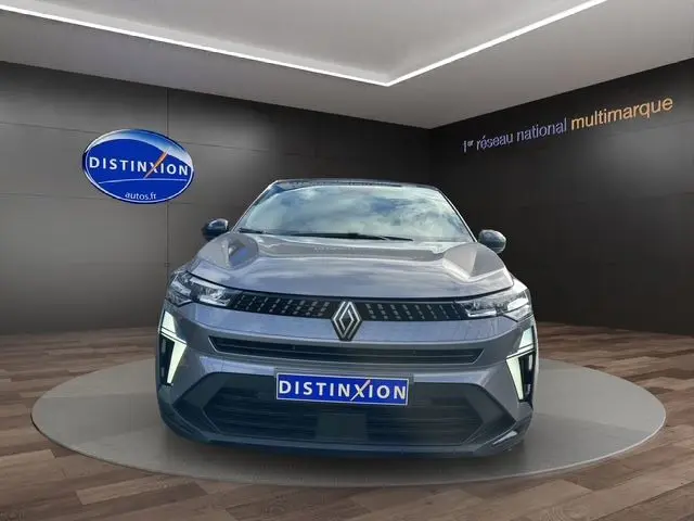 Vue de face du Renault Captur 2025 gris Cassiopée avec toit noir, éclairage LED distinctif et calandre moderne.