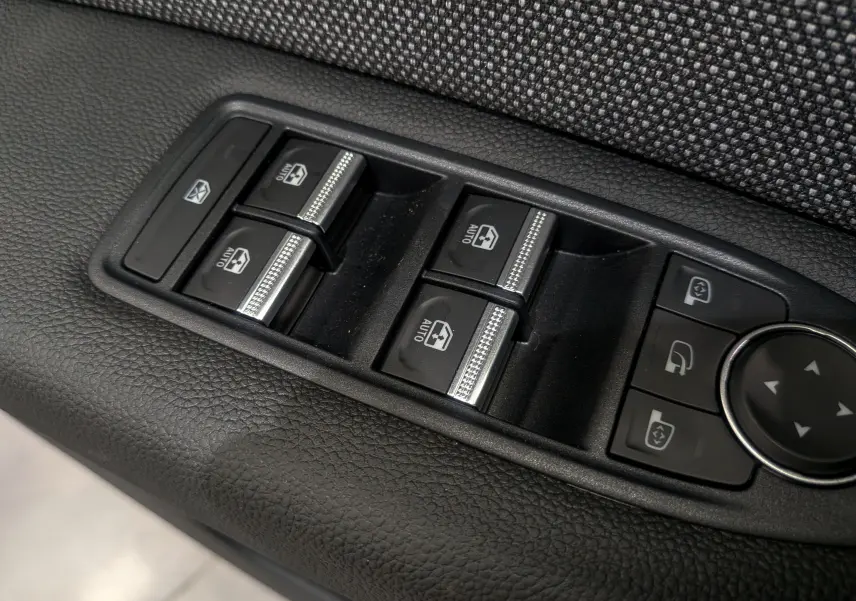 Gros plan sur les commandes des vitres électriques et rétroviseurs du côté gauche intérieur d'un Renault Captur 2025.