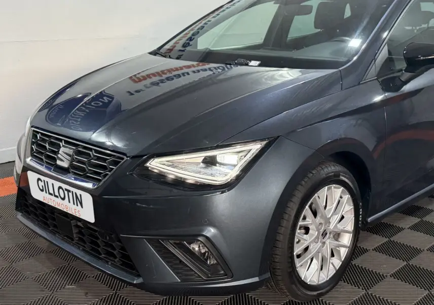 SEAT Ibiza 1.0 TSI 110 FR gris foncé vue 3/4 avant droit avec phares LED et jantes alliage visibles.