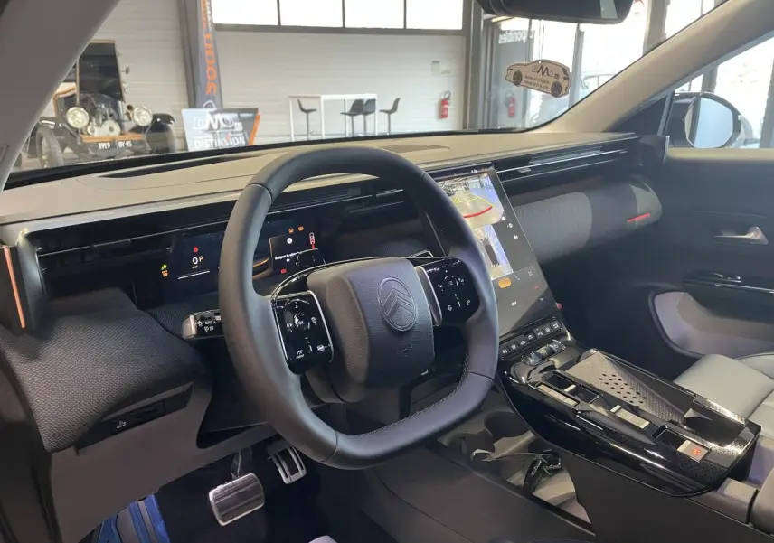 Intérieur du Citroën C5 Aircross 2026, vue du poste de conduite avec volant noir et écran tactile vertical.