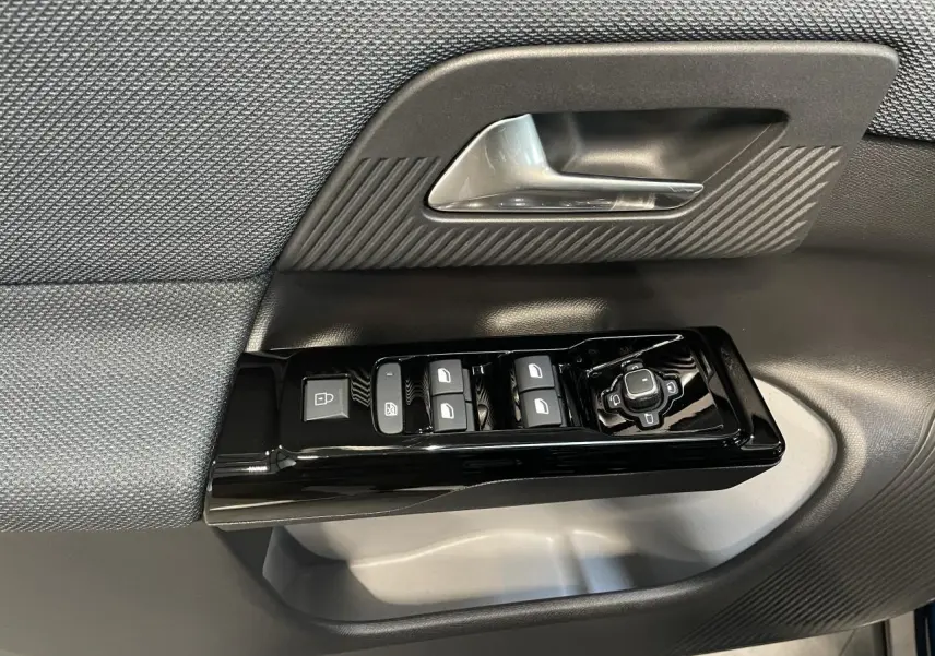 Gros plan sur la commande des vitres électriques et rétroviseurs sur la porte avant gauche d'un Citroën C5 Aircross Bleu Azul.