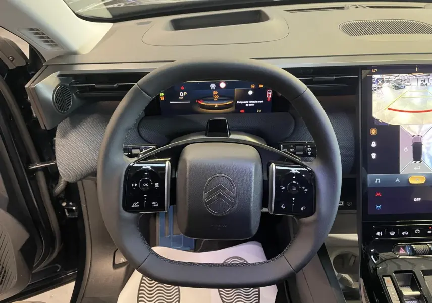 Vue intérieure centrée sur le volant noir multifonctions et les écrans numériques du tableau de bord du Citroën C5 Aircross.