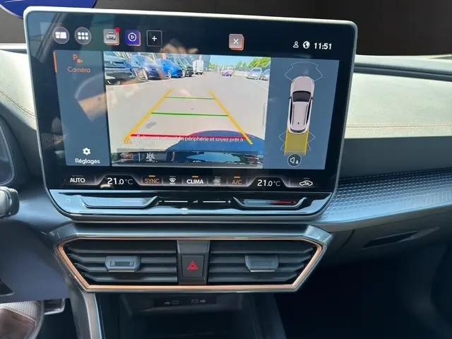 Vue rapprochée de l’écran tactile central affichant l’aide au stationnement arrière dans l’habitacle du CUPRA Formentor blanc.