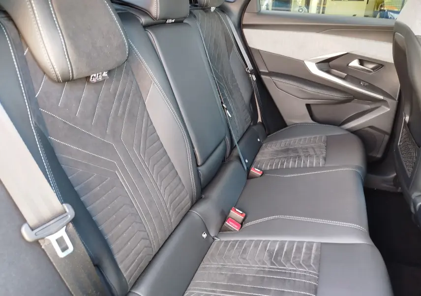 Vue intérieure des sièges arrière en cuir noir et tissu gris avec surpiqûres blanches du Peugeot 3008 2024.