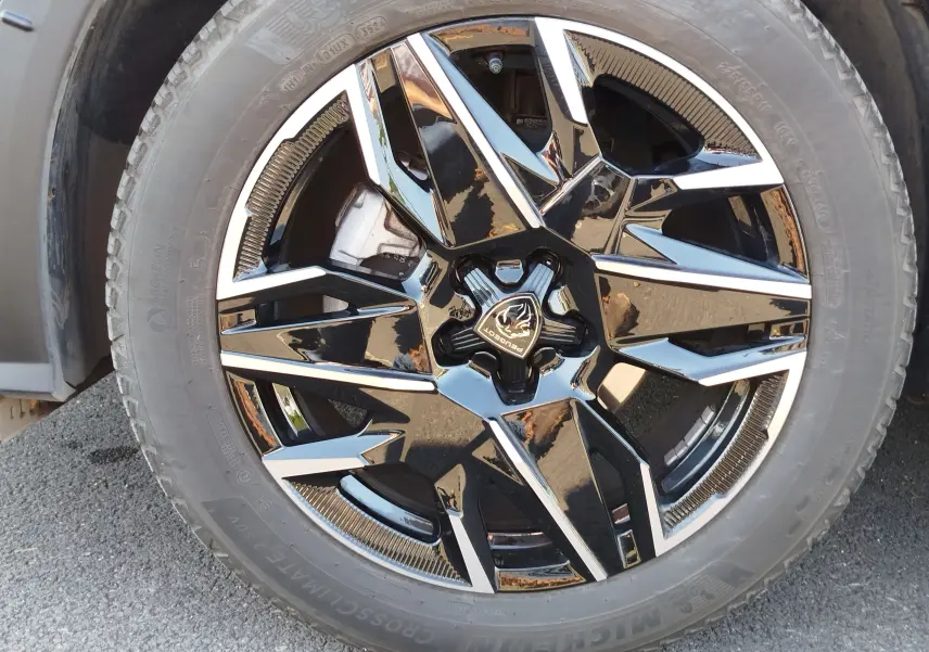 Gros plan sur la jante noire et argentée du Peugeot 3008 Bleu Obsession, mettant en valeur le logo central et le pneu Michelin.