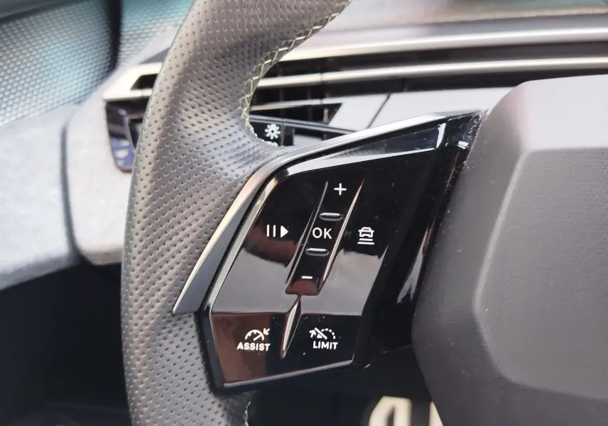 Gros plan sur les commandes multifonctions au volant en cuir perforé du Peugeot 3008 2024, finition GT Hybride.