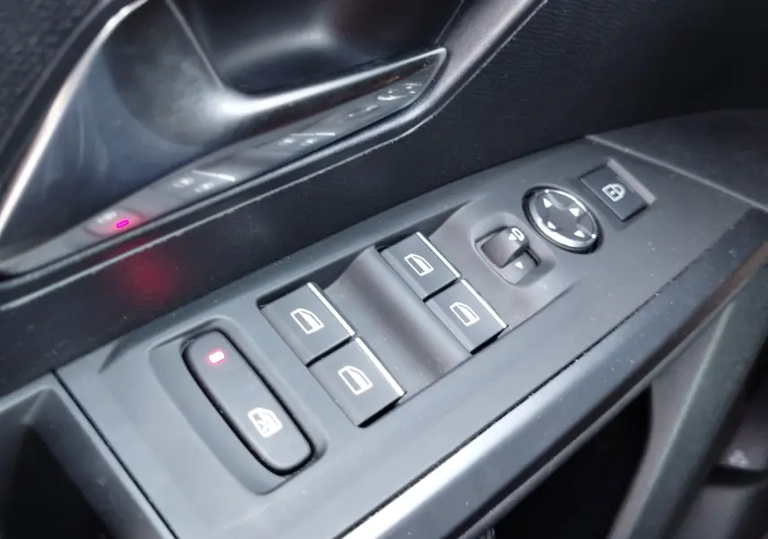 Gros plan sur les commandes de lève-vitres et rétroviseurs côté gauche intérieur d’un Peugeot 3008 2024.