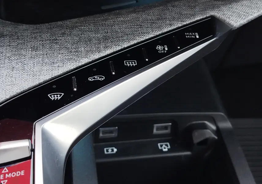 Détail du panneau de commandes de climatisation et connectiques USB dans l’habitacle gris du Peugeot 3008 Hybride 2024.