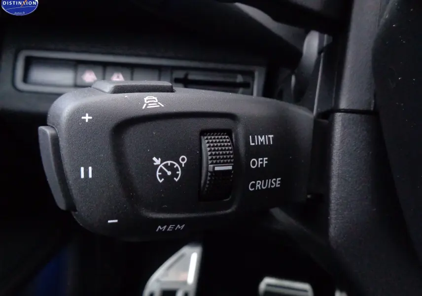 Gros plan sur la commande de régulateur de vitesse du Peugeot 3008 gris platinium, côté gauche du volant.