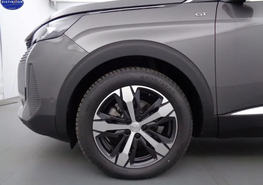 Gros plan sur la roue avant gauche et l'aile gris platinium métallisé du Peugeot 3008 GT avec logo GT visible.