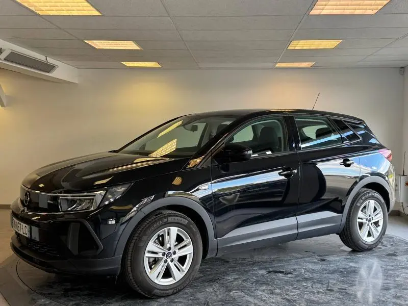 Opel Grandland 1.2 Turbo 130ch noir Karbon métallisé vue de profil côté gauche en intérieur showroom.