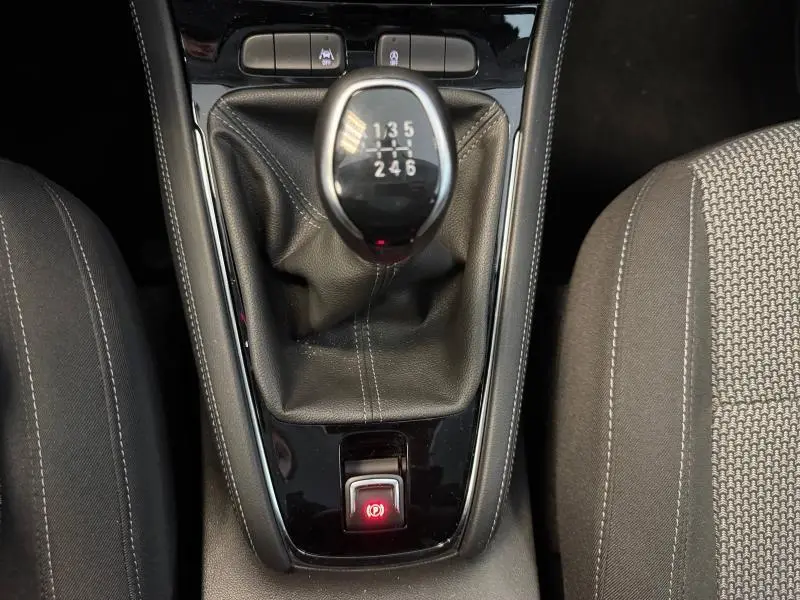 Vue rapprochée de la boîte manuelle et frein à main électrique du Opel Grandland noir Karbon 2023 avec sellerie tissu noir.