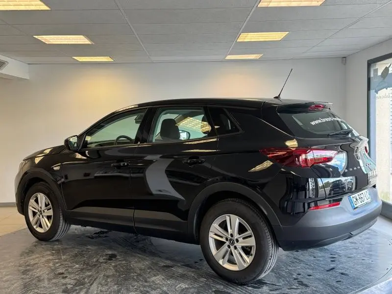 Opel Grandland noir Karbon métallisé vu de profil côté gauche dans un showroom lumineux avec jantes alu.