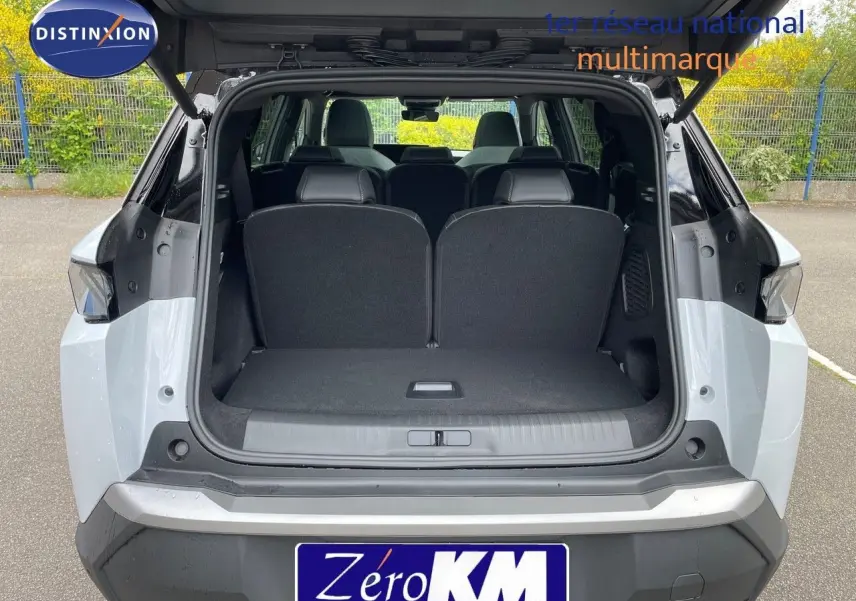 Vue arrière ouverte du Peugeot 5008 HYBRID 136CH GT blanc okenite avec toit noir, montrant le coffre spacieux.