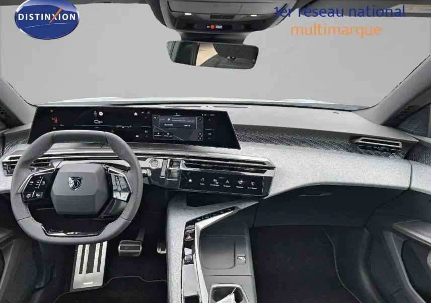 Intérieur moderne du Peugeot 5008 Hybrid 136ch GT 2025, vue frontale sur le tableau de bord et volant compact noir.