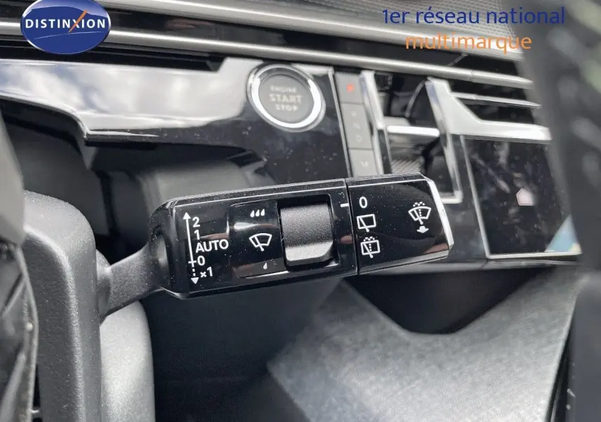 Gros plan sur la commande d'essuie-glace à gauche du volant dans l'habitacle du Peugeot 5008 Hybrid blanc 2025.