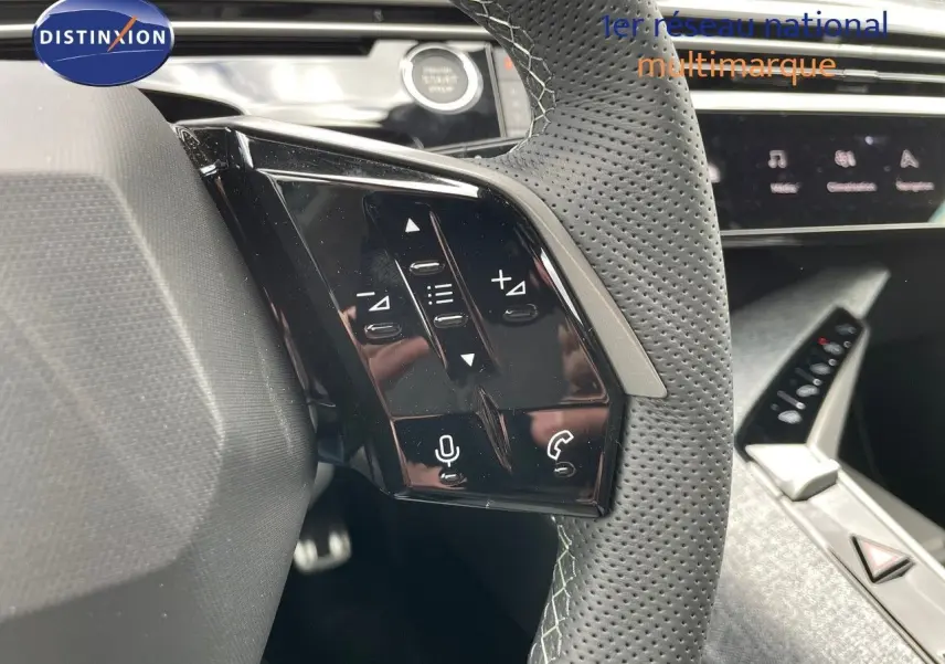 Gros plan sur le volant perforé et ses commandes tactiles du Peugeot 5008 Hybrid blanc Okenite avec toit noir, intérieur moderne.