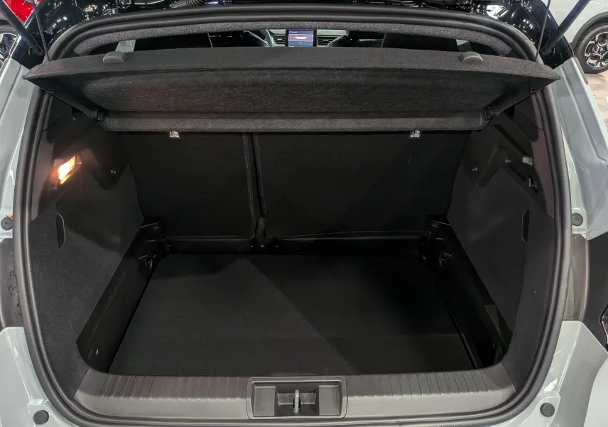 Coffre ouvert vu de l'arrière d'un Renault Captur 2025 gris Rafale avec toit noir, montrant un espace de chargement vide et propre.