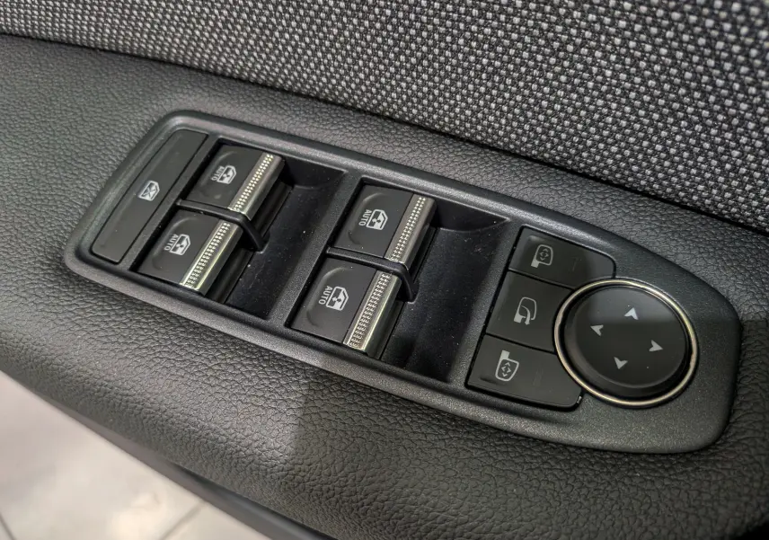 Panneau de commandes des vitres électriques et rétroviseurs sur la porte côté gauche du Renault Captur Gris Rafale 2025.