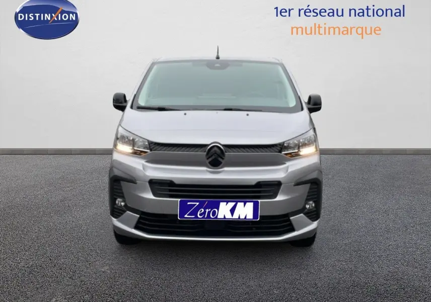 Vue de face du Citroën Jumpy Van Long L3 gris Artense métal avec calandre et phares allumés sur fond neutre.