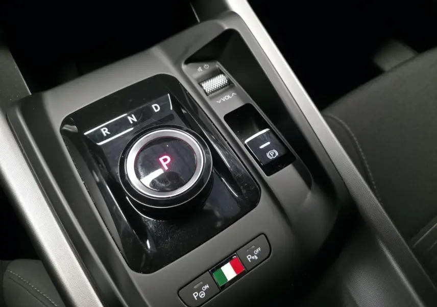 Vue rapprochée du sélecteur de boîte automatique et commandes de stationnement de l'Alfa Romeo Tonale bleu 2025.