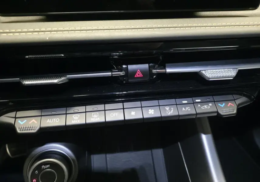 Vue rapprochée de la console centrale de l'Alfa Romeo Tonale 2025, avec commandes climatisation et bouton de danger.