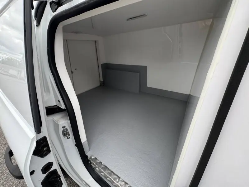 Vue intérieure de la caisse isotherme blanche du Renault Kangoo Van L2, montrant l’espace de chargement vide et propre.