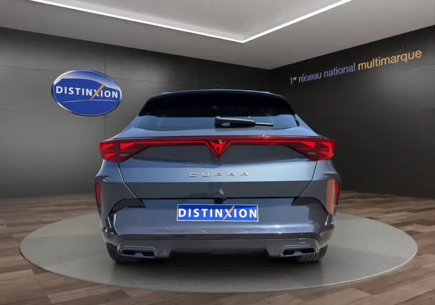 Vue arrière d'une CUPRA Formentor gris foncé avec feux arrière LED reliés et double sortie d'échappement intégrée.