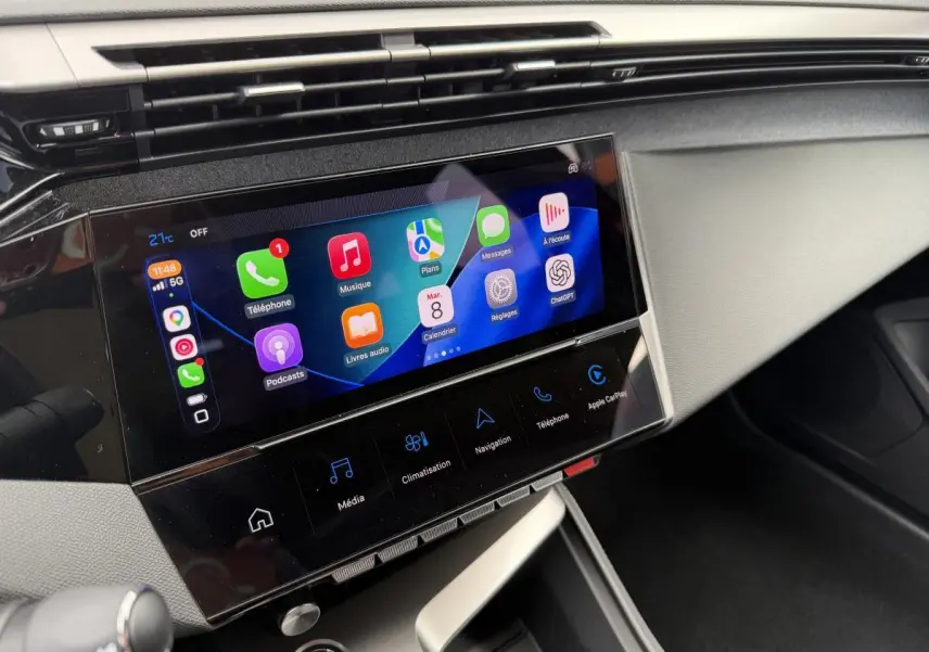 Écran tactile central 10'' du Peugeot 308 SW 2024, affichant Apple CarPlay et commandes multimédia, vue intérieure côté passager.