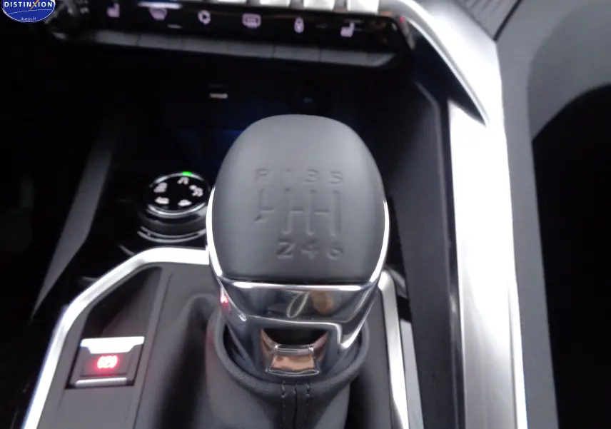 Le levier de vitesses manuel gris mat du Peugeot 3008 2023, entouré d'inserts chromés et d'un bouton de frein à main électronique.