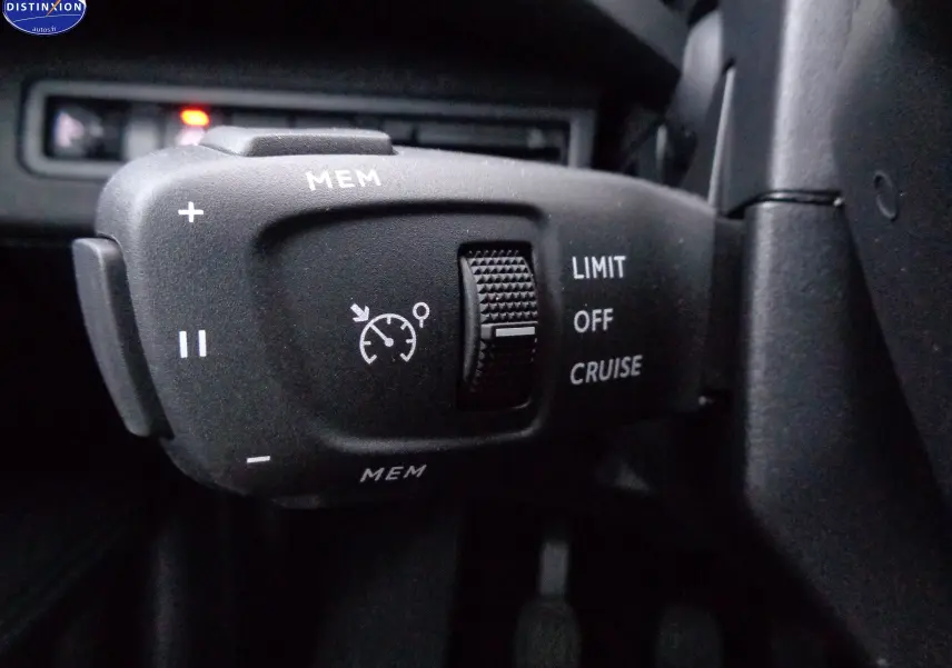 Gros plan sur la commande de régulateur de vitesse du Peugeot 3008 noir perle métal, côté gauche du volant.