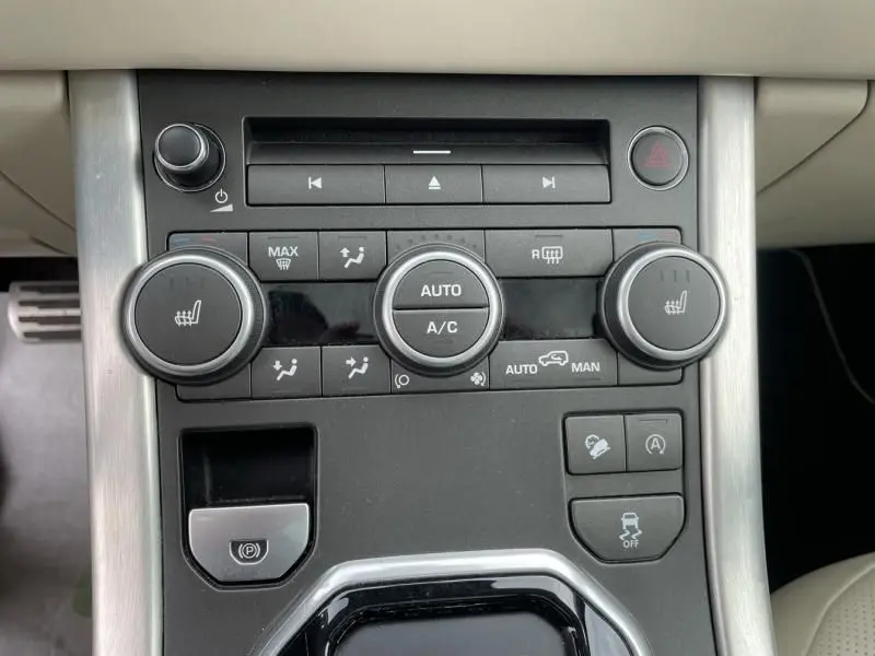 Vue rapprochée de la console centrale du Range Rover Evoque marron métal 2017, avec commandes climatisation et sièges chauffants.