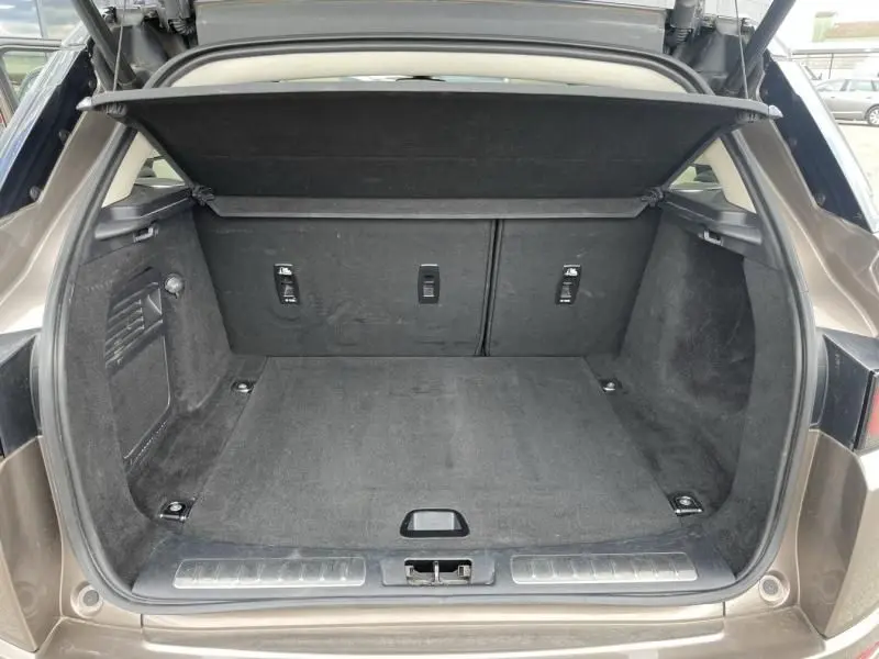 Coffre ouvert vu de l'arrière d'un Range Rover Evoque TD4 180 Autobiography 2017 marron métal, intérieur noir.