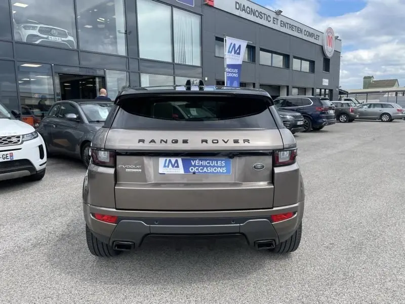 Vue arrière d'un Range Rover Evoque marron métal 2017, avec double sortie d'échappement et logo Land Rover visible.