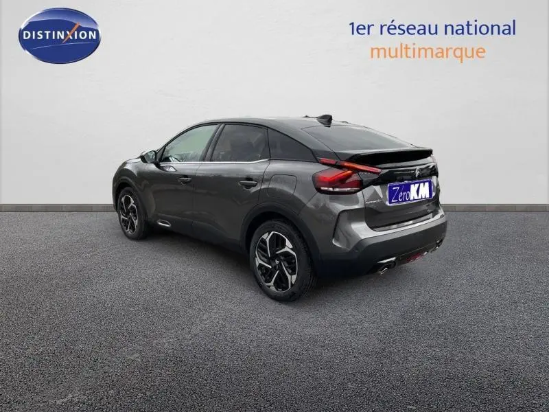 Vue 3/4 arrière droite d'une Citroën C4 gris métallisé 2024 avec feux arrière LED et jantes alliage distinctives.