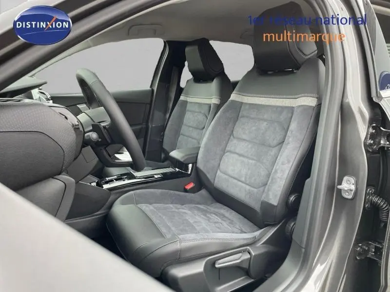 Intérieur avant droit de la Citroën C4 gris, sièges en tissu et cuir avec accoudoir central et volant cuir.