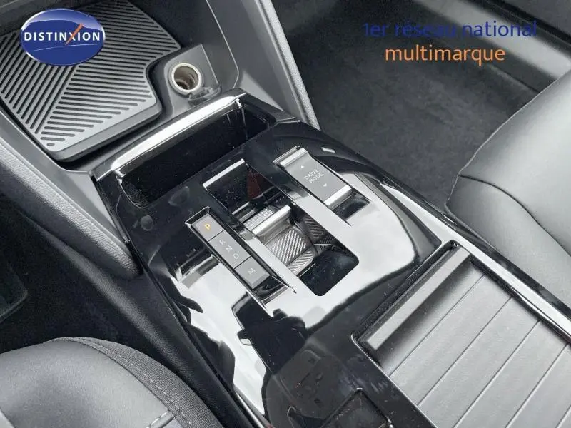 Gros plan sur la console centrale noire brillante avec levier de vitesses automatique de la Citroën C4 gris 2024 hybride