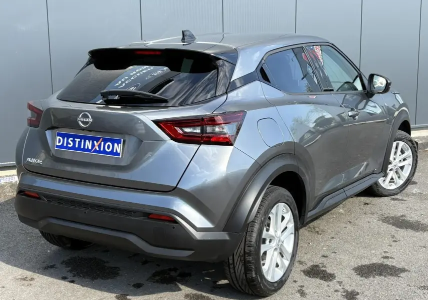 Nissan Juke gris Dark Metal vu en 3/4 arrière droit, avec jantes alliage et vitres teintées.