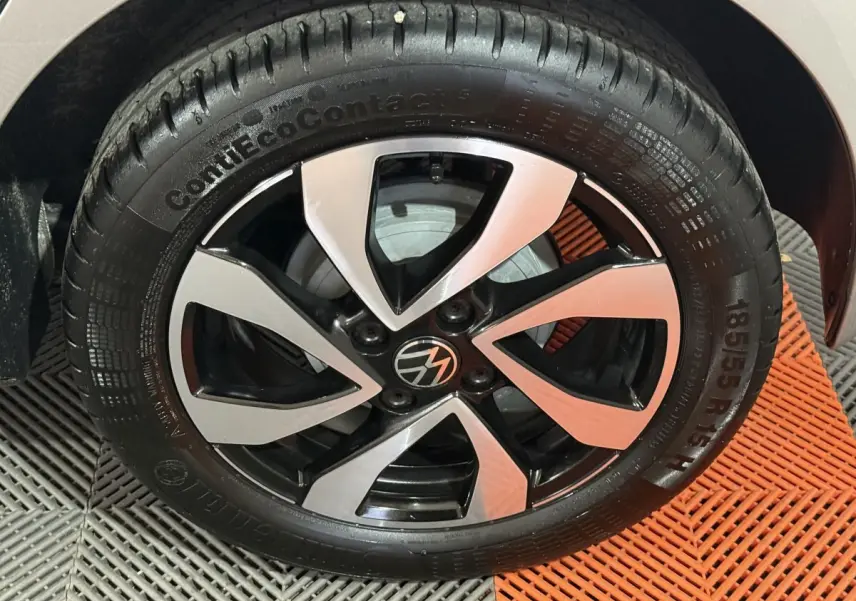 Gros plan sur la jante alliage bicolore noir et argent d'une Volkswagen Up gris foncé, vue côté droit.