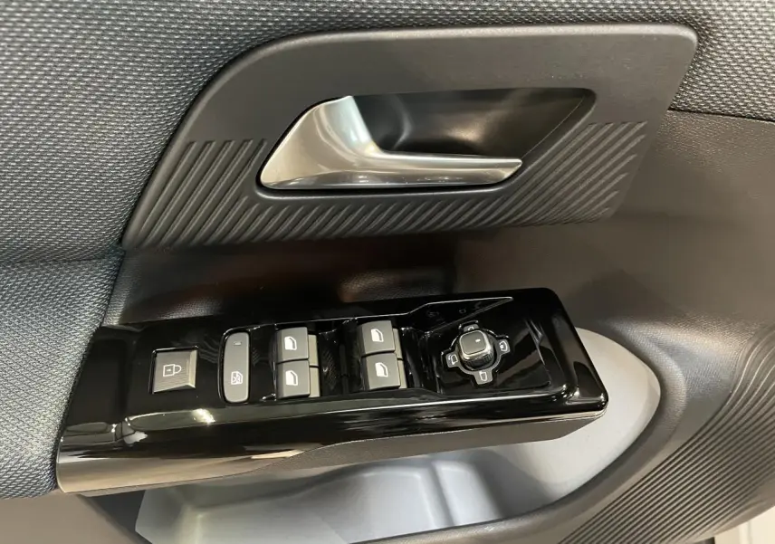 Gros plan sur la commande des vitres et rétroviseurs côté conducteur du Citroën C5 Aircross avec garniture noire texturée.