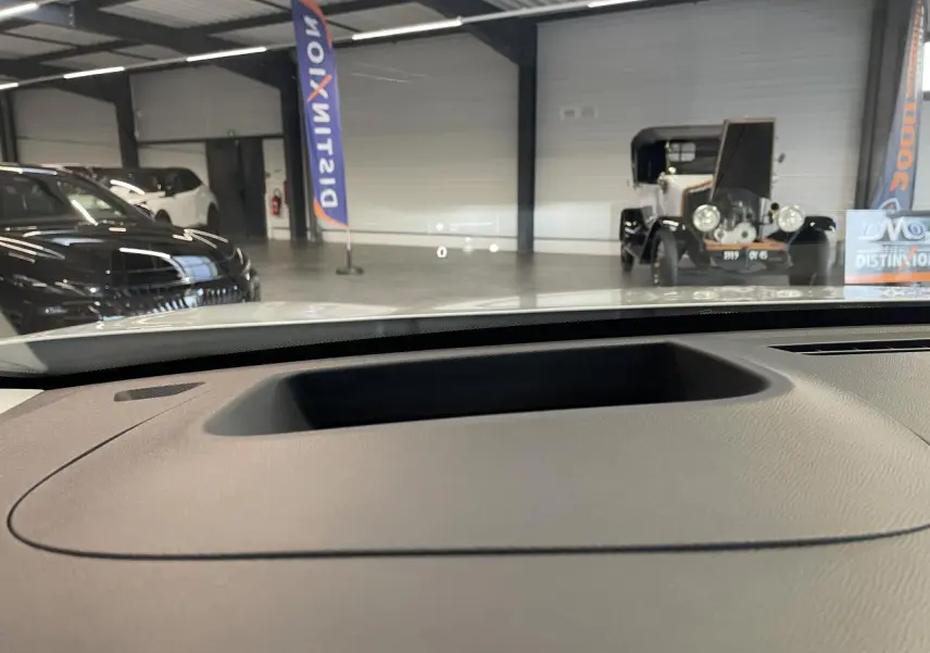 Vue depuis l'intérieur sur le tableau de bord du Citroën C5 Aircross blanc, avec affichage tête haute visible sur le pare-brise.