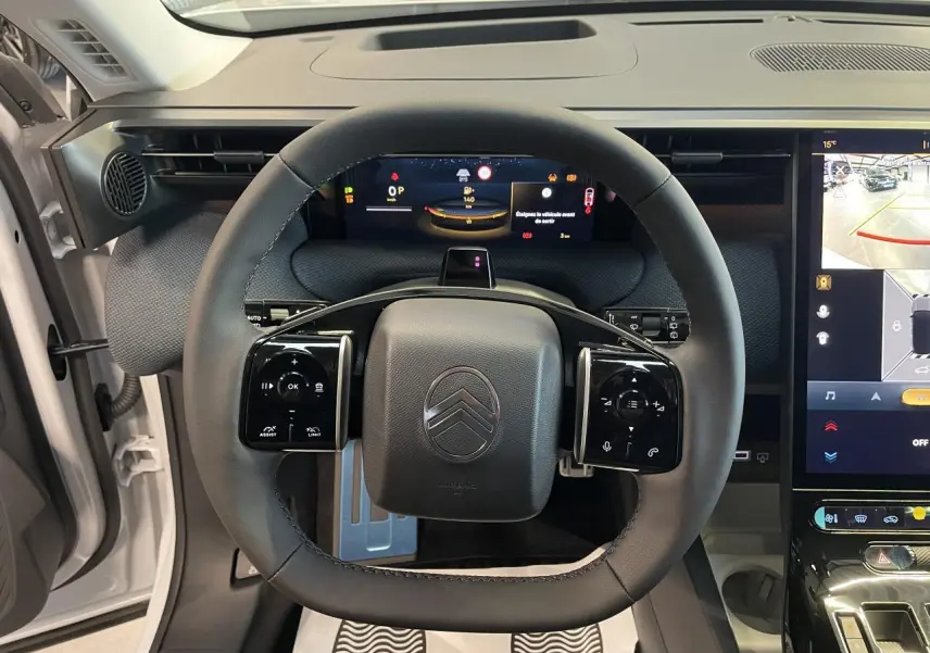 Vue frontale du volant noir du Citroën C5 Aircross 2026 blanc, avec tableau de bord numérique et écran tactile central.