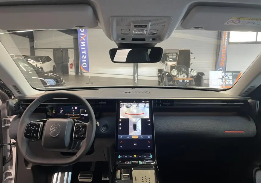 Vue intérieure frontale du Citroën C5 Aircross blanc, tableau de bord noir avec écran tactile vertical et volant multifonctions.