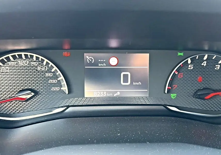 Vue rapprochée du tableau de bord numérique du Peugeot 2008 1.2 100 style, affichant 8233 km et compte-tours.