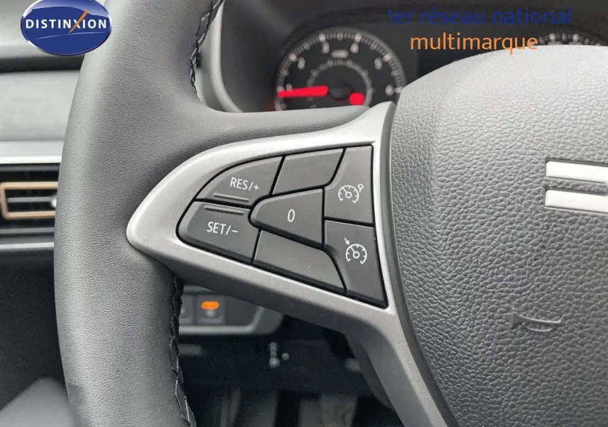Gros plan sur le volant noir avec commandes de régulateur de vitesse du Dacia Jogger 2024, intérieur gris.
