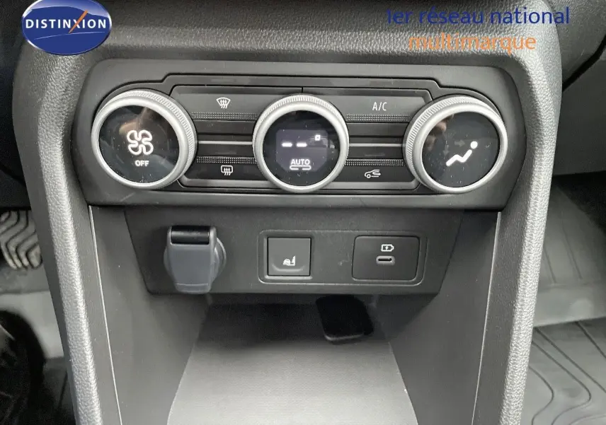 Vue rapprochée du tableau de bord central du Dacia Jogger noir nacré, montrant les commandes de climatisation et prises USB.