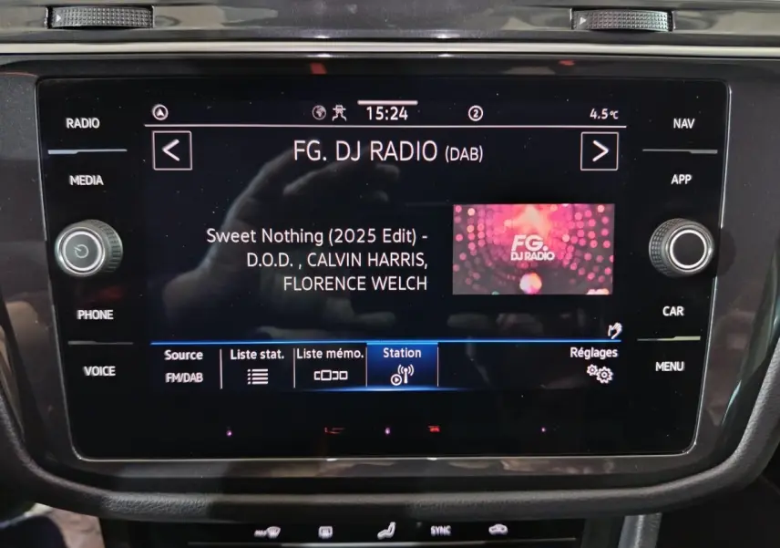 Écran tactile central du Volkswagen Tiguan 1.5 TSI bleu, affichant la radio FG DJ Radio en intérieur.