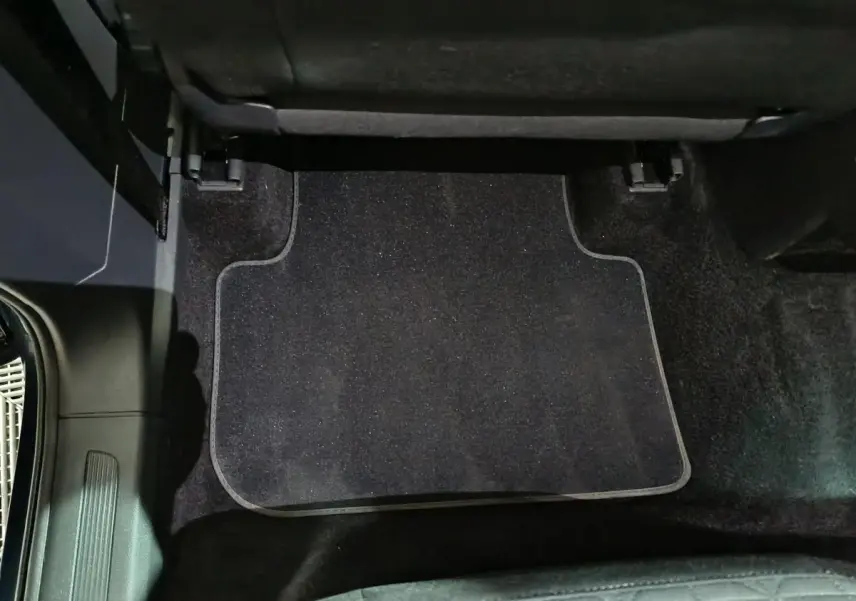 Vue rapprochée du tapis de sol noir côté arrière droit du Volkswagen Tiguan bleu 2021, intérieur propre et soigné.