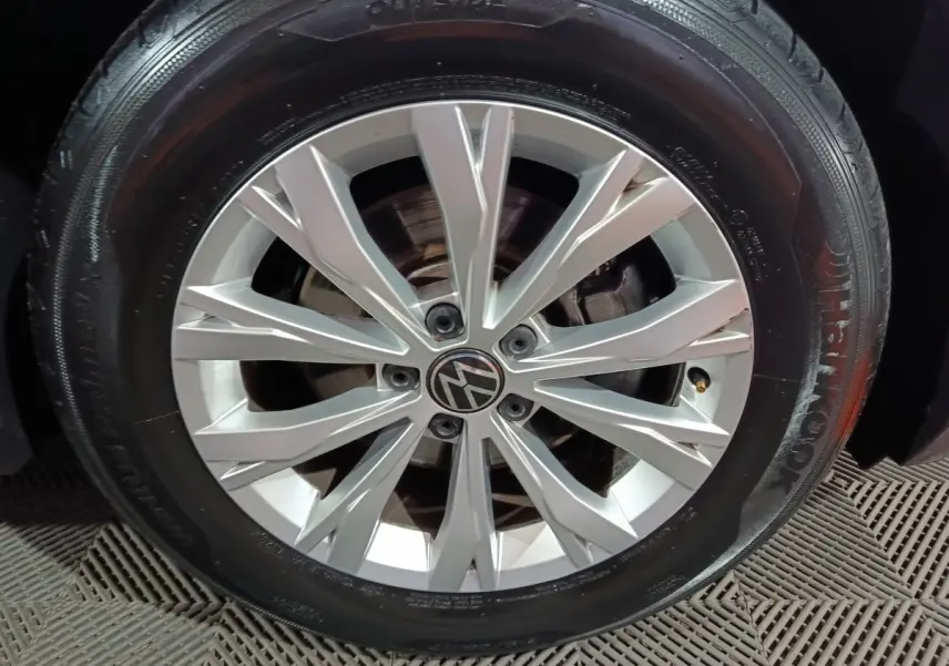 Gros plan sur la jante alliage argentée avec logo Volkswagen, montée sur pneu Hankook noir du Tiguan bleu.