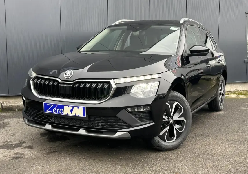 Vue 3/4 avant droit d'un Skoda Kamiq noir Magic avec calandre chromée et jantes alliage 16 pouces.